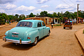 Vintage car and horse-drawn carriage on a rural street, Australia, Cuba, Matanzas, West Indies, Central America