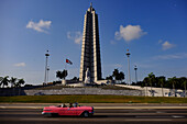 Antique car drives by Jose Marti Monument in Plaza de la Revolucion (Revolution Square), Havana, Cuba, West Indies, Central America