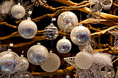 Germany, Cologne. Annual Christmas Market vendor booth, display of silver and white holiday glass ornaments.