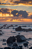 USA, Hawaii, Big Island von Hawaii. Laupahoehoe Point Beach Park, Sonnenaufgang über Wellen und rauem Vulkangestein.