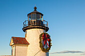 USA, Massachusetts, Nantucket-Insel. Nantucket Town, Brant Point Lighthouse mit einem Weihnachtskranz in der Abenddämmerung.