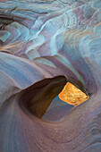 Usa, Nevada, Valley of Fire State Park. Slot canyon swirling polished sandstone design with small pool of water reflecting canyon cliffs