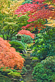USA, Oregon, Portland. Stone tower and pond in Portland Japanese Garden