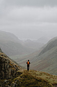 Male hiker looking at tranquil, majestic mountain landscape, Great End, England