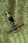 Traktor bei der Ernte von grünem Heu, Baden-Württemberg, Deutschland, Luftaufnahme