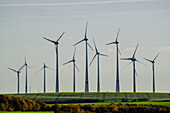 Hoch aufragende Windkraftanlagen auf dem Gebiet der sonnigen ländlichen Landschaft, Deutschland