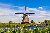 Canal tour boat and windmill in Unesco World Heritage Site, Kinderdijk, Holland, Netherlands.