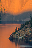 Sonnenuntergang färbt das Wasser im Crater Lake National Park, Oregon, USA