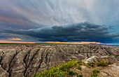 Dramatische Gewitterwolke bei Sonnenaufgang im Badlands National Park, South Dakota, USA