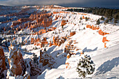 USA, Utah, Bryce-Canyon-Nationalpark. Wintersonnenaufgang auf schneebedeckter Landschaft.