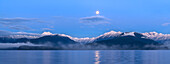 USA, Washington State, Seabeck. Panoramic of moon setting over Olympic Mountains and Hood Canal.