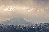 Japan, Hokkaido, Tsurui. Gott Strahlen scheinen über Berg.