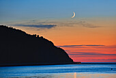 Kanada, Québec, Mont-Louis. Mondsichel-Sonnenaufgang über dem Golf von St. Lawrence.