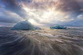 Europa, Island, Gletscherlagune Jokulsarlon. Wellen umspülen gestrandete Eisberge.