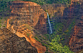 Kauai Hawaii scenic Waimea Canyon State Park red cliffs from above canyon with distant waterfall
