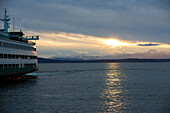 Seattle, Bundesstaat Washington. Fahrt mit der Bainbridge Island Ferry bei Sonnenuntergang mit Blick auf die Olympic Mountains