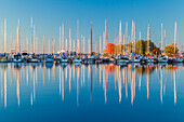 USA, Wisconsin. Panoramablick auf die Herbstfarben, die sich auf dem ruhigen Wasser des Hafens von Bayfield am Lake Superior spiegeln.