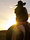North America; USA; Wyoming; Shell; Big Horn Mountains; Cowgirl in silouette with sunset