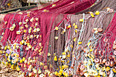 Fishing nets hung out to dry with colorful floats at Praia das Burras on the island of Príncipe in West Africa