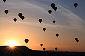Türkei, Anatolien, Kappadokien, Göreme. Heißluftballons fliegen über Felsformationen und Feldlandschaften im Nationalpark Göreme, UNESCO-Weltkulturerbe.
