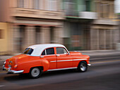 Kuba, Havanna, Havanna Vieja, UNESCO-Weltkulturerbe, klassisches rotes Auto in Bewegung