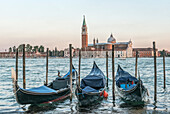 Italy, Venice. Gondolas on the waterfront with San Giorgio Maggiore Church in the background