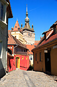 Siebenbürgen, Rumänien, Kreis Mures, Sighisoara, Wohnstraße mit Kopfsteinpflaster im Dorf. UNESCO-Weltkulturerbe. Stadtsymbol, Glockenturm.