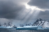 Antarctica, South Georgia Island. Sunbeams light up icebergs