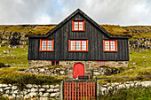 Europa, Färöer. Blick auf das Dorf Kirkjubour, berühmt für die Ruinen einer alten Kathedrale, Kirkjubomururin, auf der Insel Streymoy