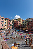 Bathers in late summer on Boccadasse beach, Genoa, Liguria, Italy.