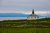 Norwegen, Lofoten, kleine Kirche am Fjord, bei regnerischem Wetter