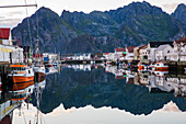 Hanningsvaer, Lofoten, Norwegen, Kanal mit Fischerbooten bei Dämmerung\n