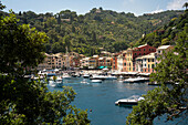 Italien, Provinz Genua, Portofino. Gehobenes Fischerdorf am Ligurischen Meer, pastellfarbene Gebäude mit Blick auf den Hafen