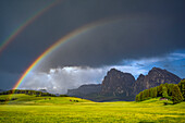 Europe, Italy, Dolomites, Alpe di Siusi. Double rainbow over mountain meadow