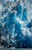 USA, Alaska, Tracy Arm-Fords Terror Wilderness, Icebergs calving from blue ice face of South Sawyer Glacier in Tracy Arm on summer afternoon
