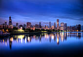 Die Skyline von Chicago spiegelt sich während eines blauen Sonnenaufgangs im Lake Michigan wider