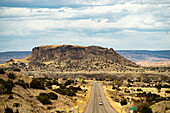 Road in landscape with mesa mountain, New Mexico.