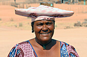 Namibia; Kunene Region; Central Namibia; on the Ugab River; Herero woman in traditional dress and with a typical headgear