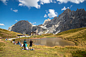 Baita Segantini, tourists around a small lake. Passo Rolle, San Martino di Castrozza Village, Trento district, Trentino Alto Adige, Italy
