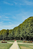 Frau in Rot zu Fuß durch den Parc du Cinquantenaire in Brüssel, Belgien