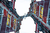 Doppelbelichtung verdrehte Häuser, die sich um eine Statue in Gent, Belgien, drehen
