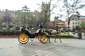Pferdekutsche mit Touristen in der Altstadt von Sevilla Andalusien, Spanien  