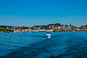 Rückansicht von einem Motorboot mit Stadtbild und Vierwaldstättersee an einem sonnigen Sommertag in Luzern, Schweiz.