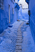 Morocco, Chefchaouen. A quiet alleyway in blue, the typical paint color of the village.