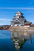 The Matsumoto Castle as seen from the bridge with the city buildings in the background, Japan