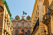 Italy, Sicily, Trapani Province, Trapani. Clock tower with the Italian flag in the city center of Trapani.