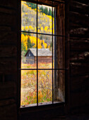 USA, Colorado. Looking out a window in the ghost town of Ashcroft in autumn near Aspen, Colorado.