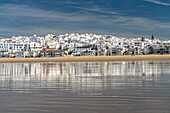Conil cityscape reflected on Playa De Los Bateles beach, Conil de la Frontera, Costa de la Luz, Andalusia, Spain