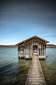 Alter Holzschuppen mit Bootssteg im See