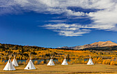 Tipis mit Yellow Mountain im Hintergrund auf dem Campingplatz Chewing Black Bones in der Nähe von St. Mary, Montana, USA
